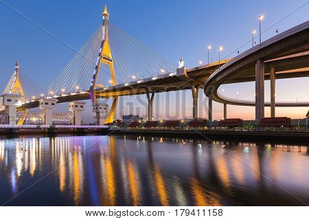 Supension bridge over watergate connect to highway overpass with water reflection light and clear blue sky background