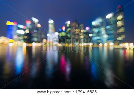 Blurred bokeh ligths night view Singapore office building downtown with reflection abstract background