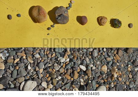 Stones against the background of yellow bedding and are like planets. Space for text