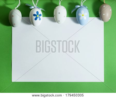Easter composition with colorful eggs on a green background with copy space