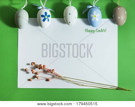 Easter composition with colorful eggs on a green background with copy space