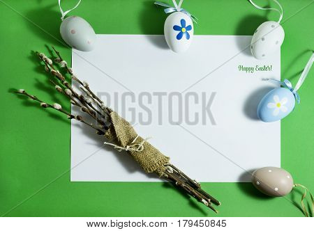 Easter composition with colorful eggs on a green background with copy space