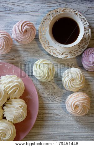 Sweet homemade dessert - marshmallow (zephyr) with cup of tea.Homemade marshmallows on a light background. Russian currant and mango zephyr.