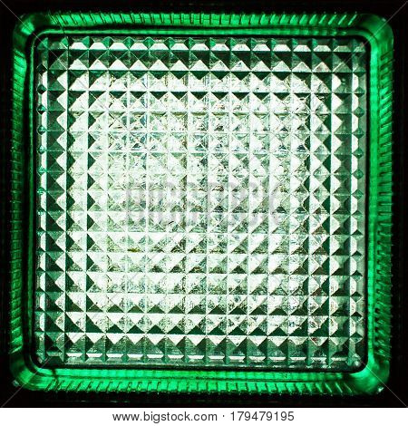 Square green glass block. Transparent building material. Element of the glass wall. Texture or background.