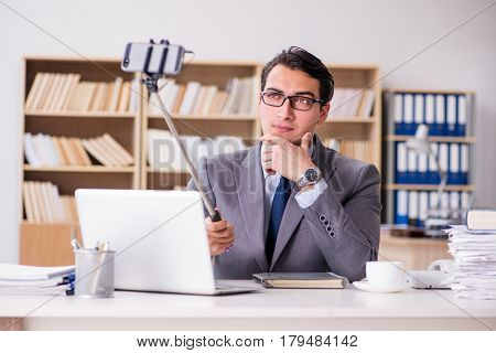 Funny businessman taking selfie in office