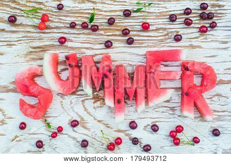 top view flat lay of sliced fresh ripe watermelon summer letters with cherries frame on a white rustic wood board background fresh outdoors summer concept