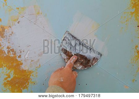 Closeup of a man aligning a wall with spatula and trowel. wall putty