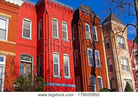 Historic urban architecture of Vernon Square neighborhood in Washington DC. Colorful residential row houses under bright afternoon sun.