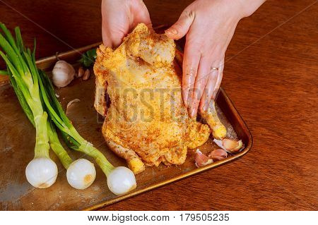 Whole raw chicken on baking paper with seasoning before cooking. RAW marinated whole chicken cook