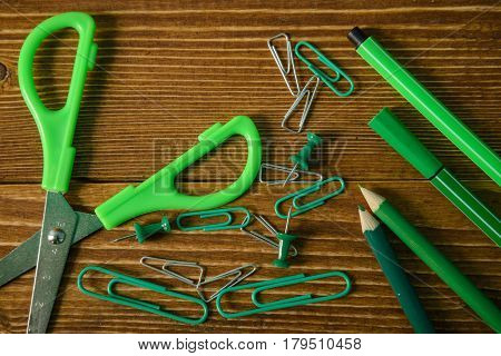 scissors and color pencils and clips on wooden background