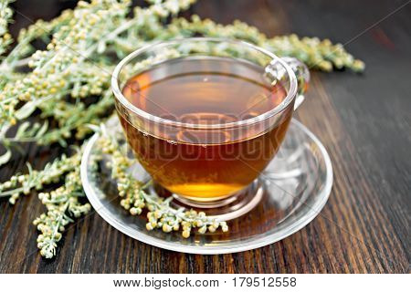 Tea With Gray Wormwood In Glass Cup On Table