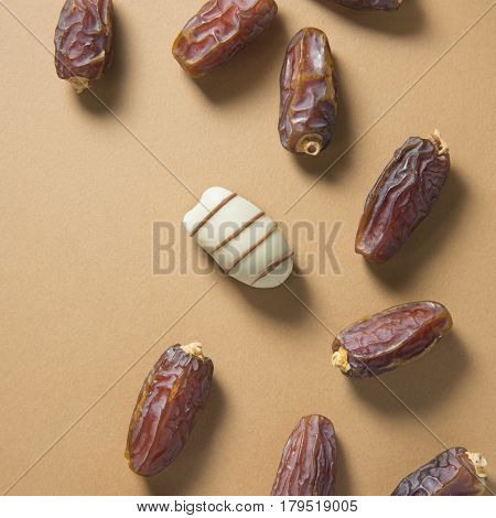 Metaphorical Concept - 'Unique' , 'isolated' or 'different' through food. Single date chocolate placed amongst regular ripen dates. Top view.