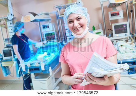 smiling female doctor portrait in front of intensive care unit for newborn baby