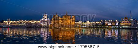 The Golden Temple at Amritsar Punjab India the most sacred icon and worship place of Sikh religion. Illuminated in the night reflected on lake.