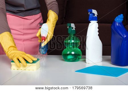 Female in uniform and gloves cleans the table
