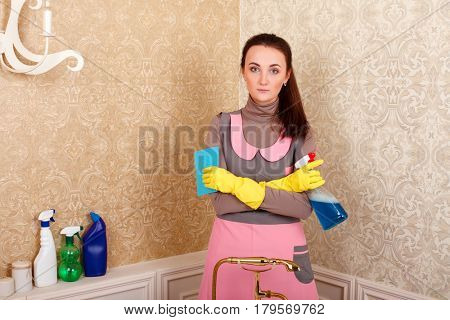 Woman in uniform and gloves with cleaning agent