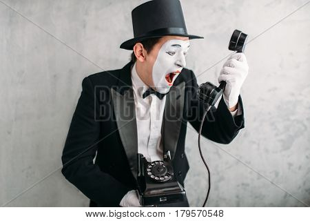 Pantomime actor performing with retro telephone