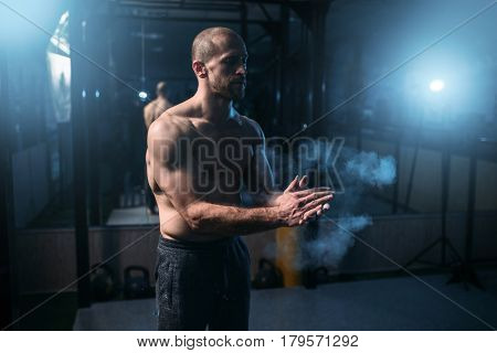 Male athlete rubs hands with talcum powder