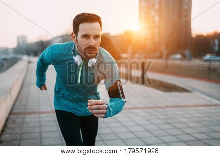 Sportsman in outfit running and jogging in city