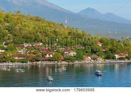 Jemeluk Beach and beautiful blue lagoon with Gunung Agung volcano on background. Amed village, East of Bali, Indonesia.