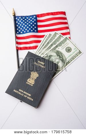 concept showing Indian passport with US currency notes or Dollars with american flag in the background, applying for US / american tourist or H-1B visa