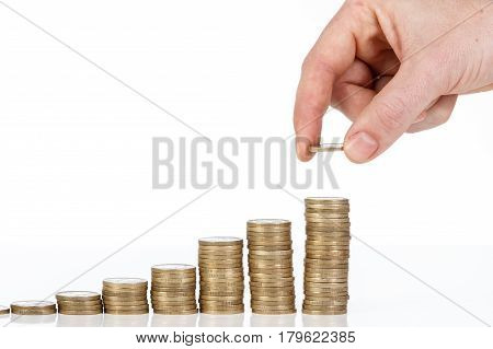 Close Up Of Male Hand Stacking One Euro Coins Into Increasing Columns.