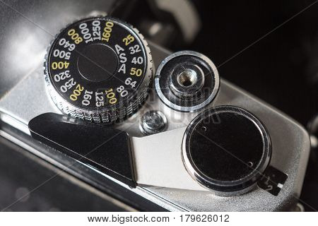 Old black film camera mode select wheel and trigger. Close-up macro photo of retro SLR