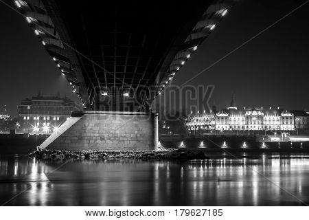 Night black and white cityscape under the Slasko-Dabrowski bridge near the old town of Warsaw, Poland