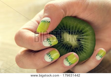 Kiwi and skin care of a beauty female hands with green and white moon nail art manicure