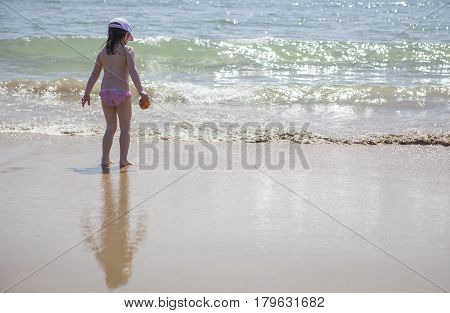 Little girl playing and splashing at beach shore. El Rompido Huelva Spain