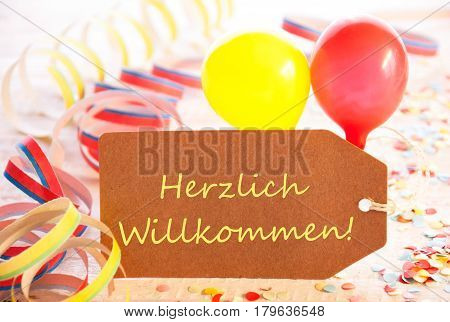 One Label With German Text Herzlichen Willkommen Means Welcome. Party Decoration Like Streamer, Confetti And Balloons. Wooden Background With Vintage, Retro Or Rustic Syle