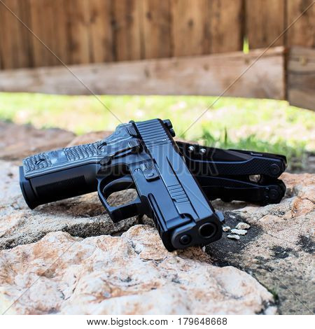 A gun and a knife on the stone