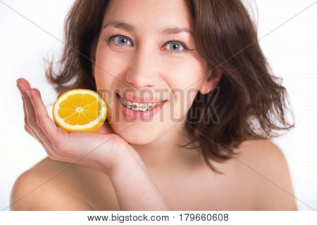 Studio portrait of a girl with multi-colored braces. Isolated on white.