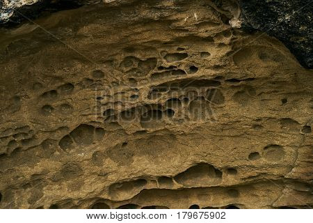 Close up of the texture of the big sandy cliff. Background of beige sand of sandy cliffs.