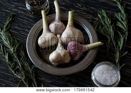 Rosemary, garlic and salt on wooden background.