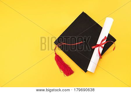 Top View Of Graduation Mortarboard And Diploma On Yellow Background, Education Concept