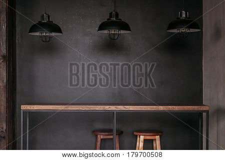 Dinning table set in loft style dining room with black lamps.