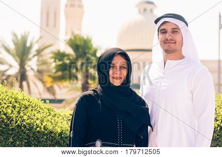 arabian couple standing in front of a mosque