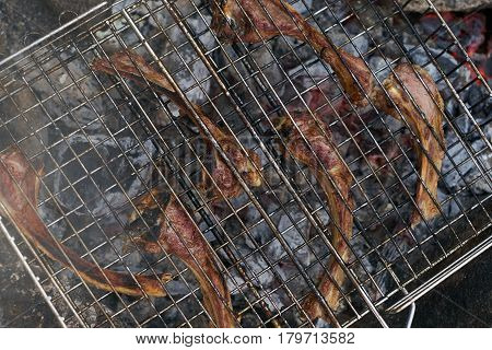 Close up of Cooking delicious barbecued lamb ribs . Lamb ribs at outdoors grill. Summer Weekend and party concept.