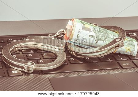 Money In Handcuffs On The Laptop Keyboard, Warm Toning. Cyber Hacker Crime Concept.
