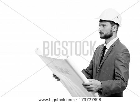 Examining blueprints. Handsome young male businessman architect in a hardhat holding blueprints posing isolated on white copyspace monochrome shot business profession builder worker career concept