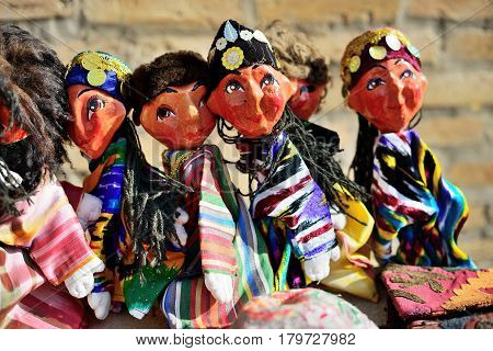 Traditional souvenir painted mashed paper (papier mache) dolls wearing in traditional costumes . Itchan Kala (Xiva Ichon Qala) UNESCO world heritage, Khiva, Uzbekistan.