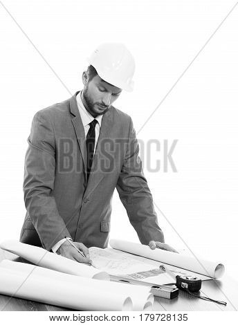 Foreman on work. Black and white vertical studio shot of a handsome professional male constructionist wearing protective helmet working on a building plan professionalism developer businessman