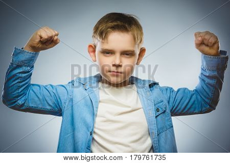 Closeup Portrait of Funny Little child. Sport Handsome Boy. Strong serious kid showing his hand biceps muscles.