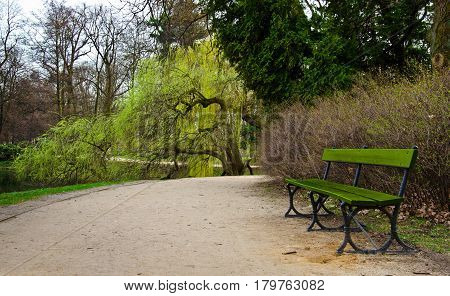 A lonely green bench in a park