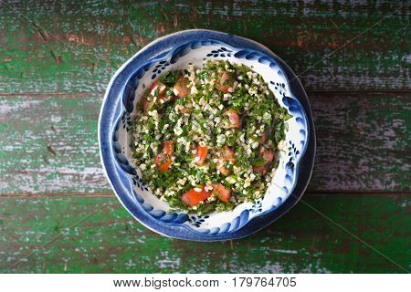 Tabouli salad on the old wooden background top view