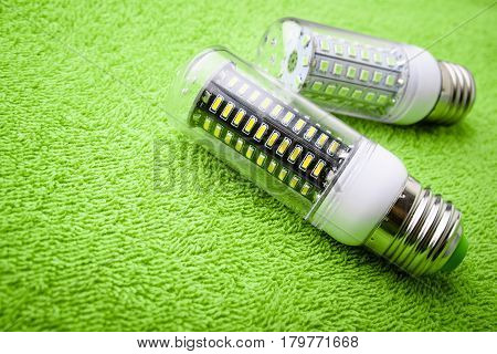 Energy saving LED light bulb on a green background with empty space