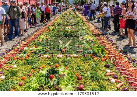 Antigua, Guatemala - March 26 2017: Locals make procession carpet of vegetables during Lent in colonial town with most famous Holy Week celebrations in Latin America.