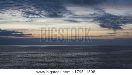 Clouds sky and sunlight sunset on horizon ocean. Silhouette person on background seascape dramatic atmosphere rays sunrise. Relax view waves water sea mockup nature evening concept perspective sunrise