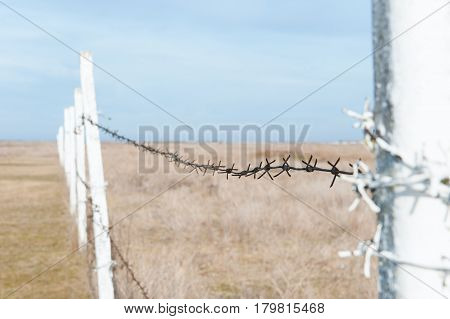 Fence with barbed wire in the field.